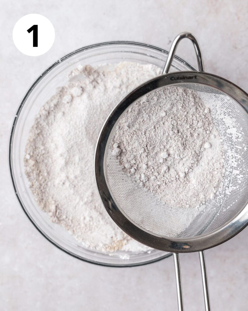 sifting almond flour powdered sugar and cocoa powder.