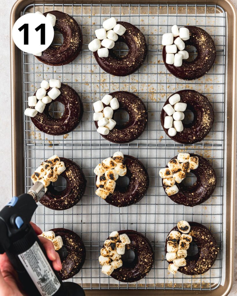 using blow torch to toast mini marshmallows on smores donuts.