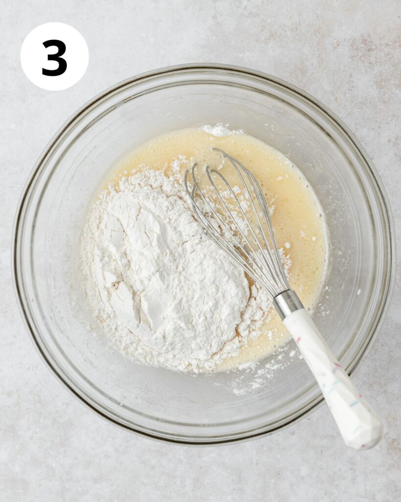 adding dry ingredients to coconut cupcake batter.