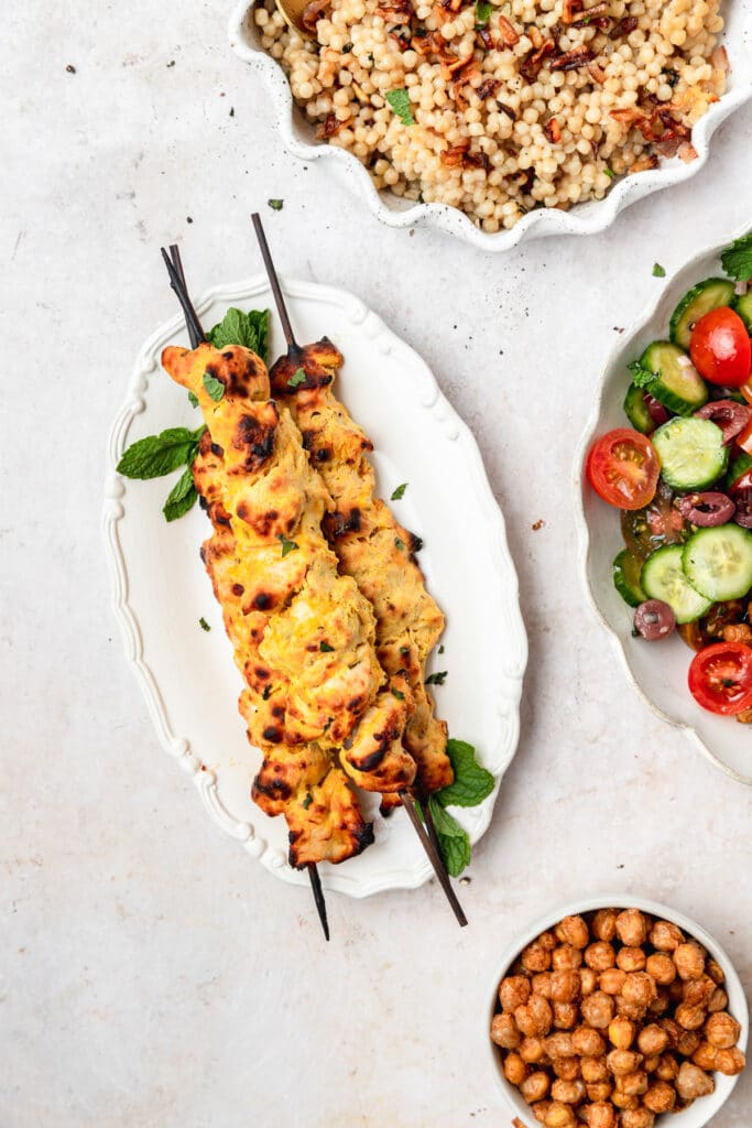 plate with grilled greek style chicken skewers.