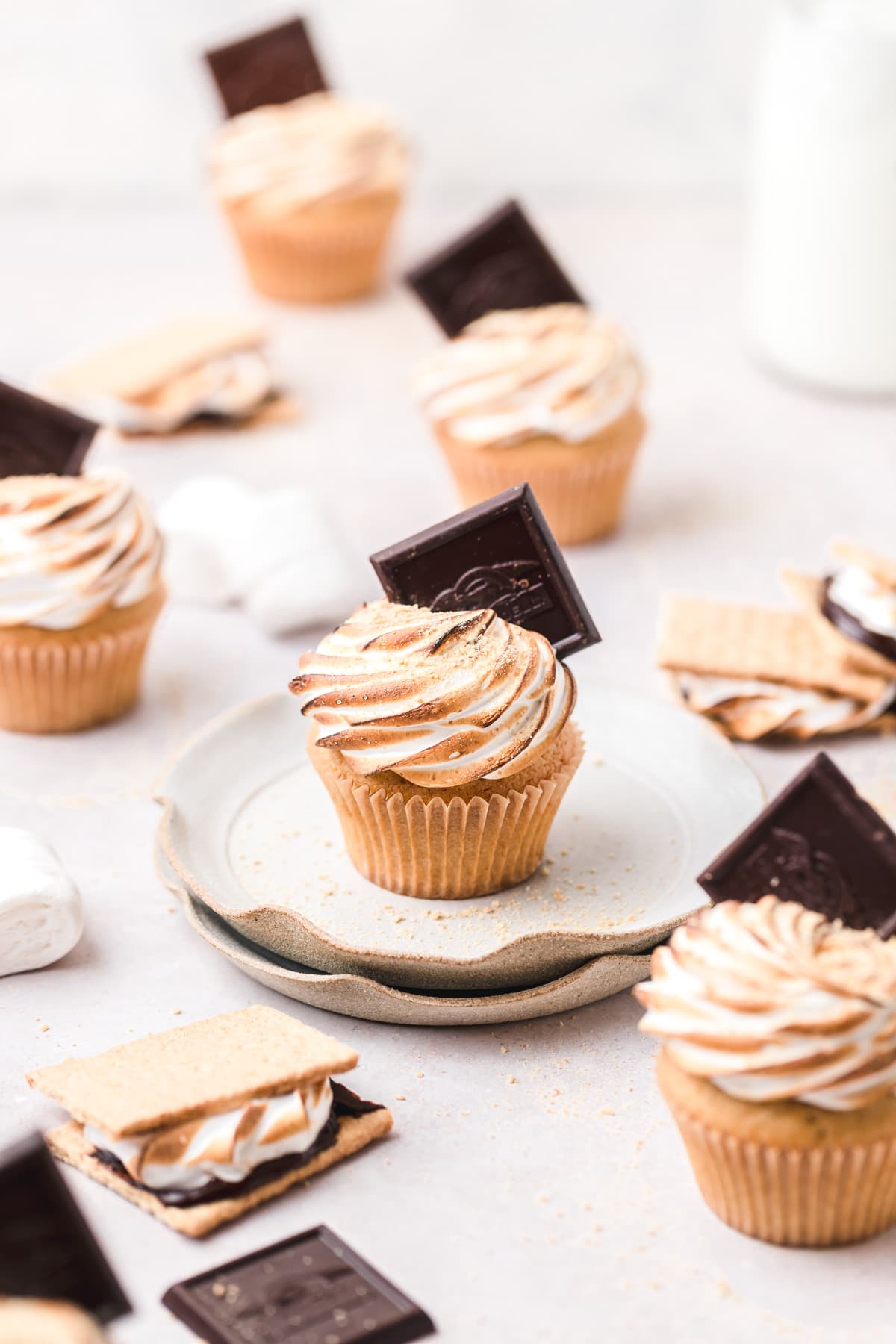 toasted smore's cupcakes with chocolate pieces on top.