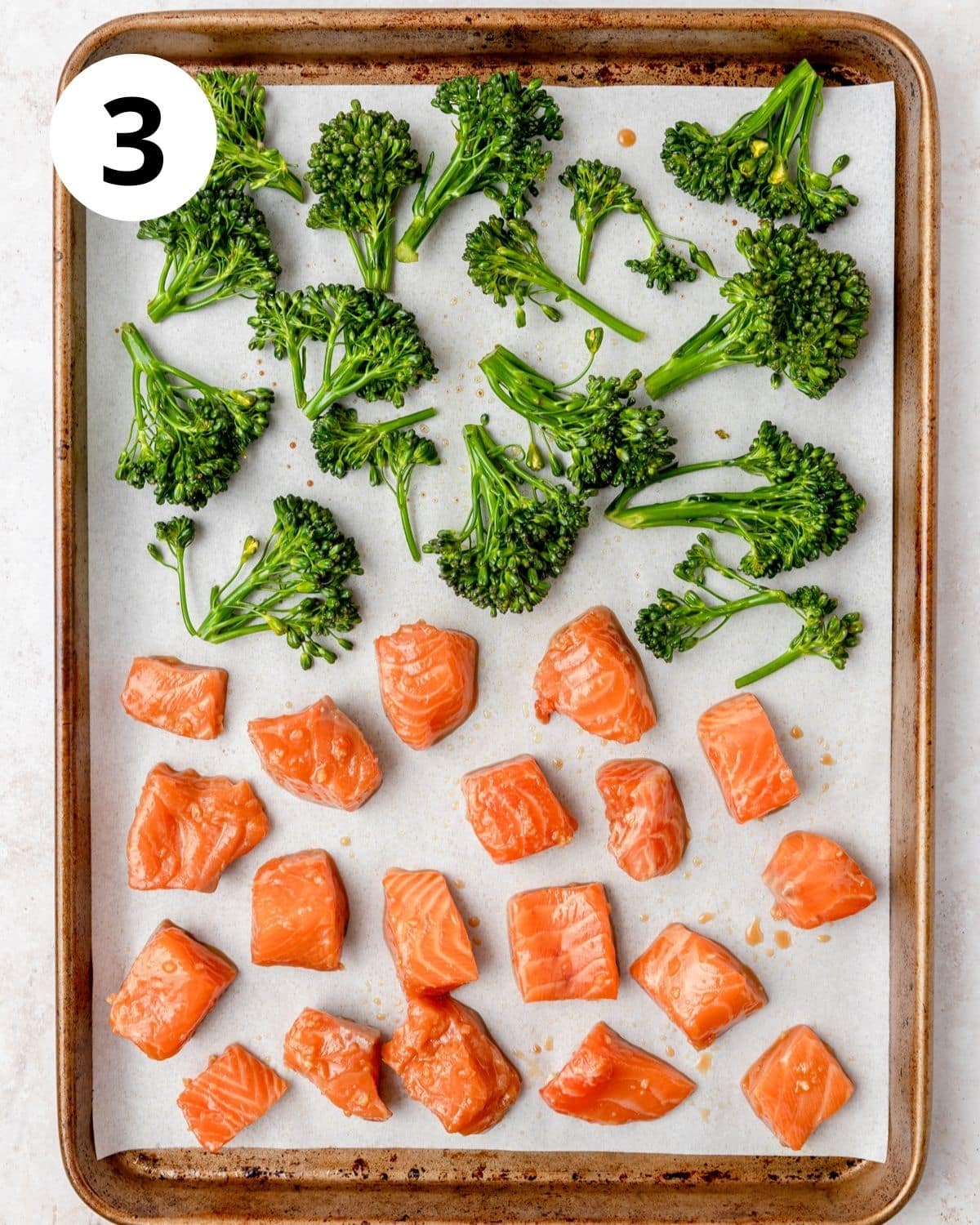 baking sheet with salmon and broccoli before roasting.