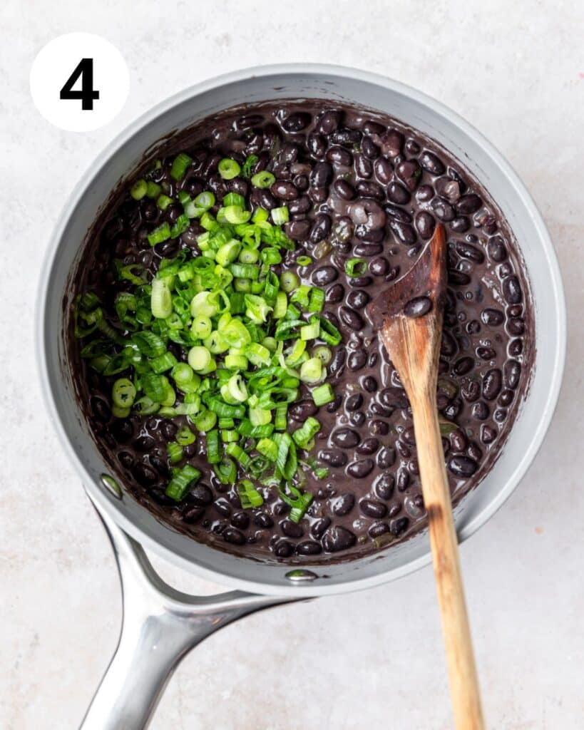 stirring green onions into black beans.