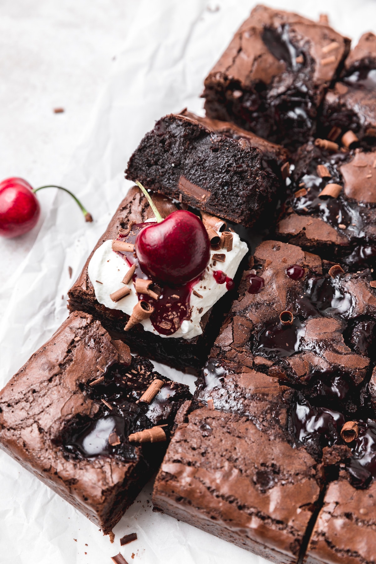 black forest brownies topped with whipped cream and fresh cherries.