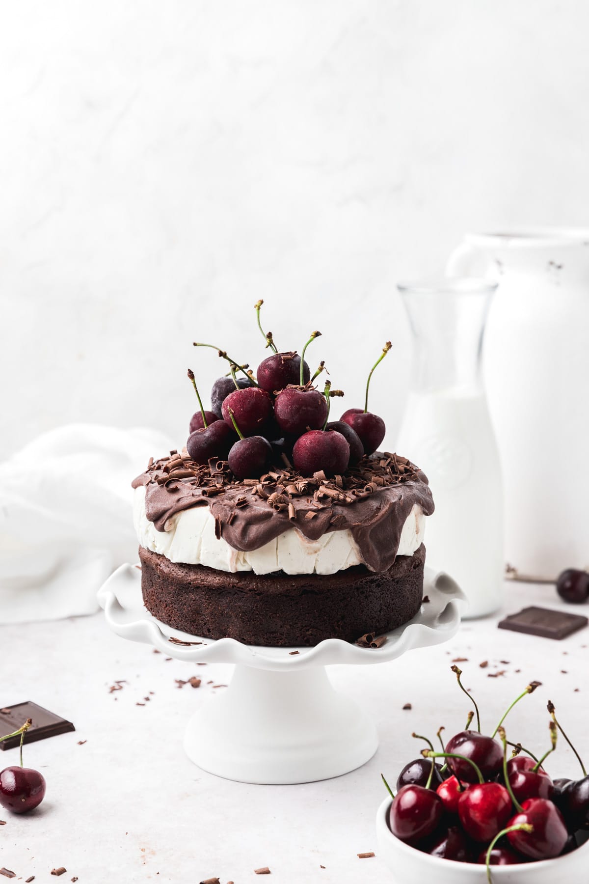 black forest ice cream cake topped with chocolate ganache and cherries.