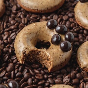 baked coffee donuts on bed of coffee beans.