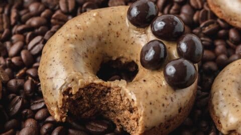 baked coffee donuts on bed of coffee beans.