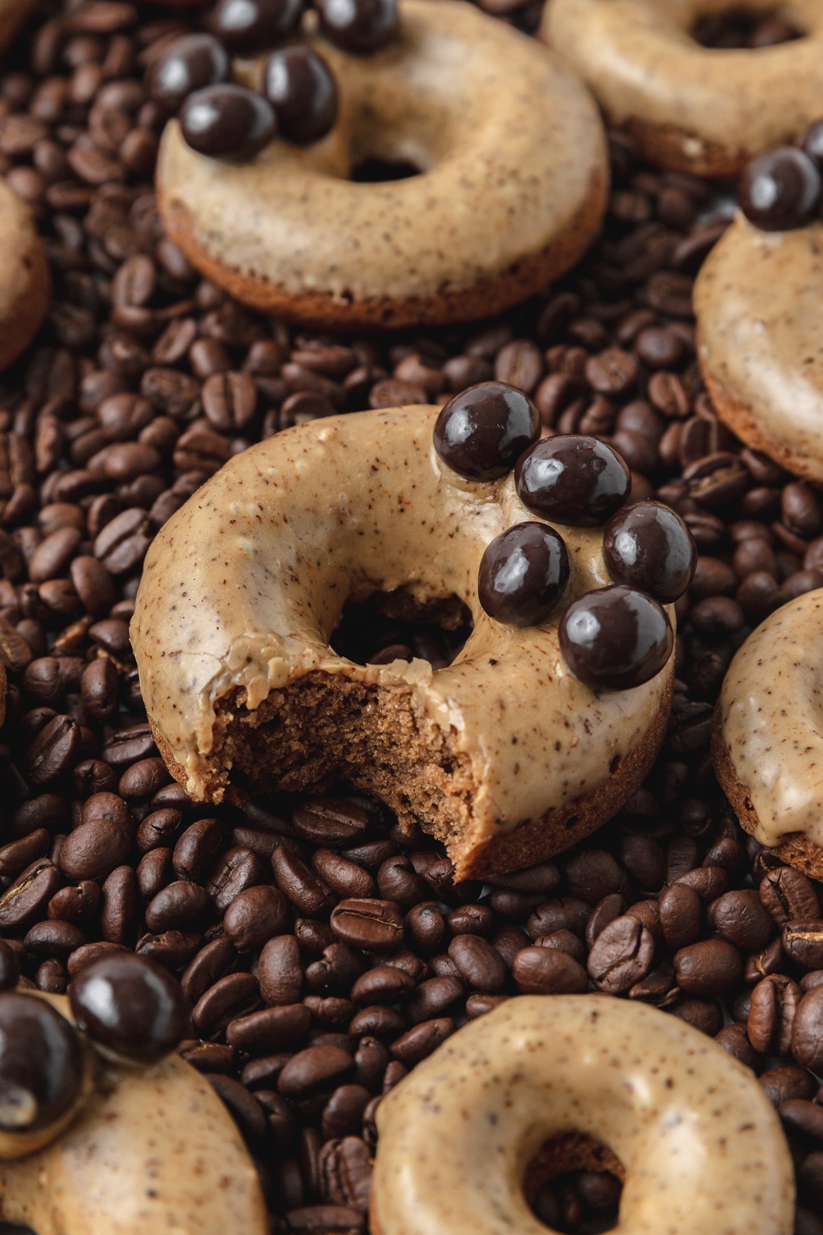 coffee baked donuts on bed of coffee beans.