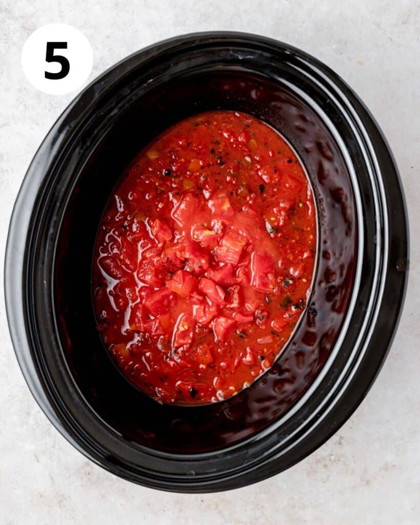 canned tomatoes in bottom of slow cooker.
