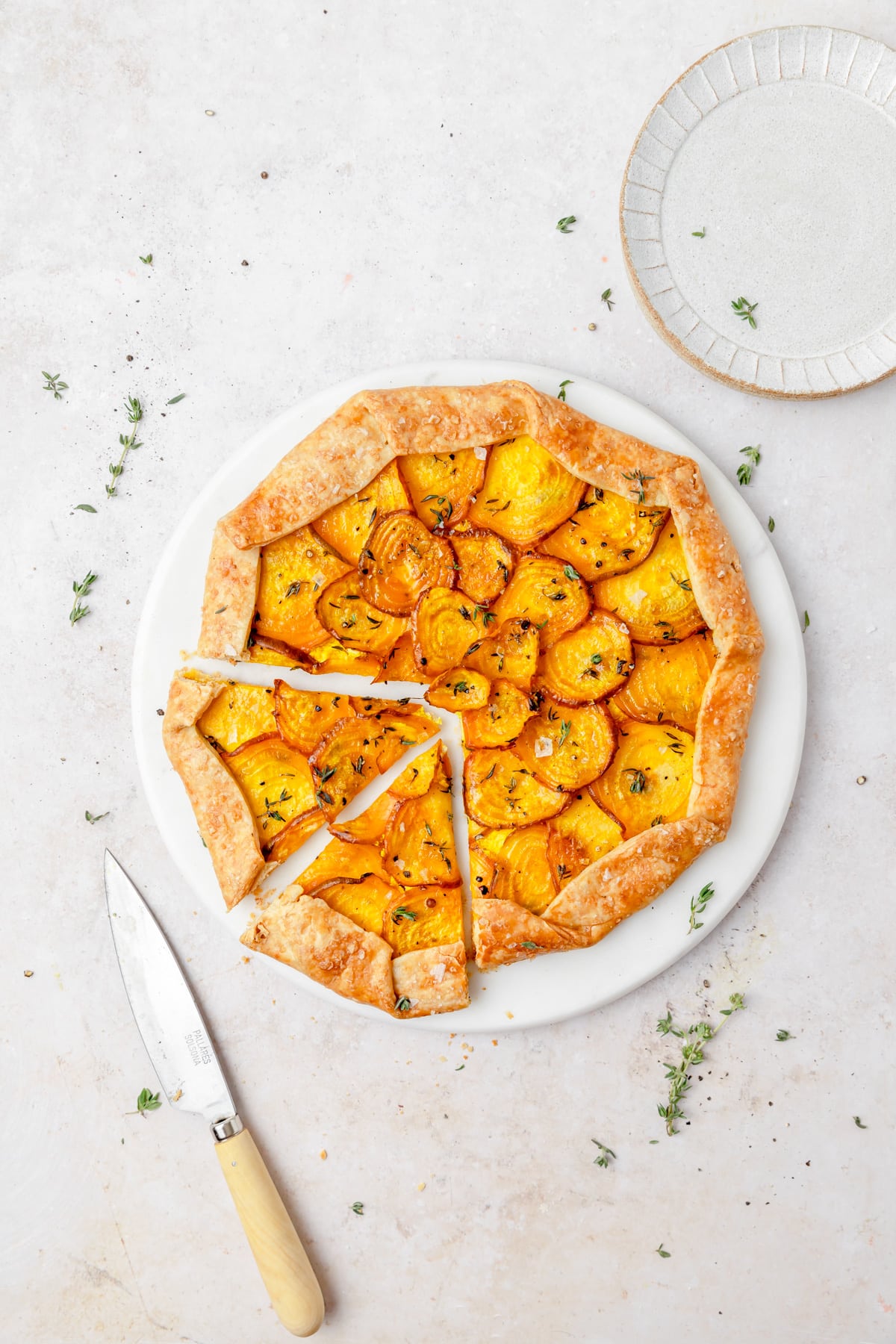 golden beet galette with parmesan pie crust cut into slices.