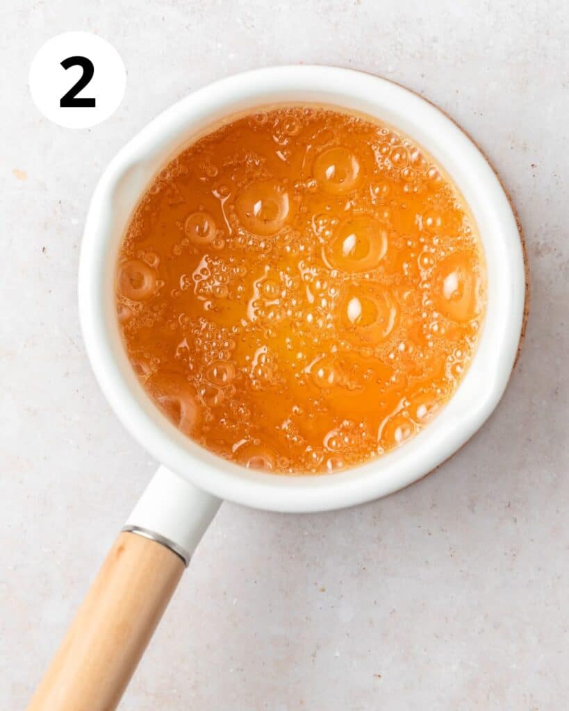 amber colored sugar and water in pot for caramel.
