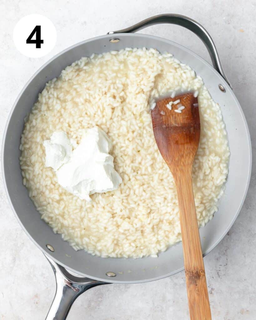 adding softened goat cheese to risotto.