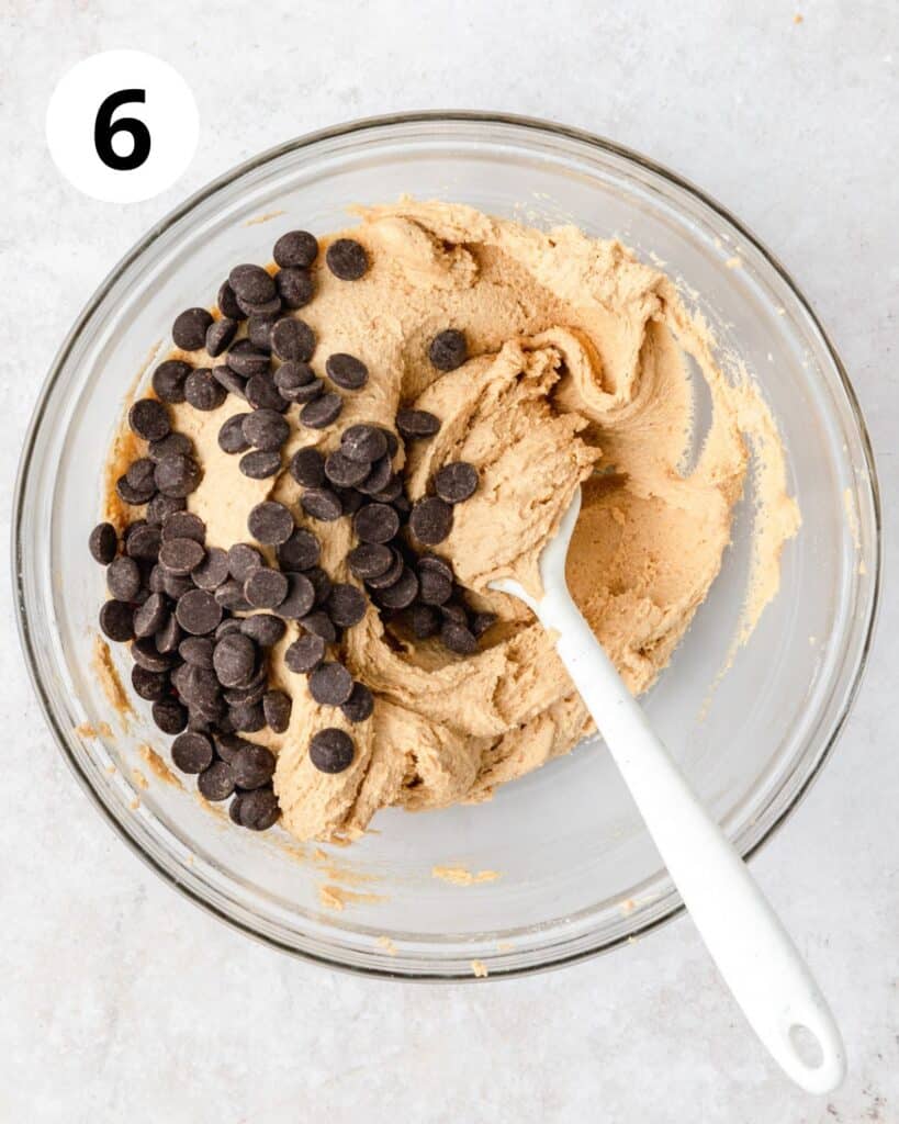 adding chocolate chips to brown butter pumpkin cookie dough.