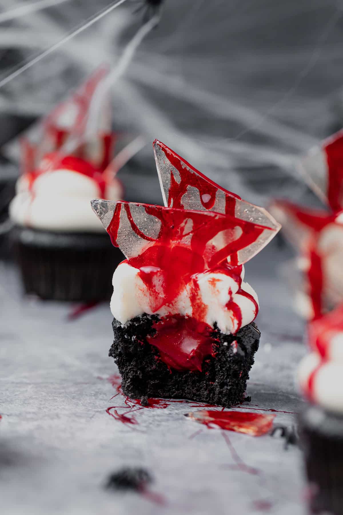bloody halloween cupcakes with bite taken out to see red chocolate ganache oozing out.
