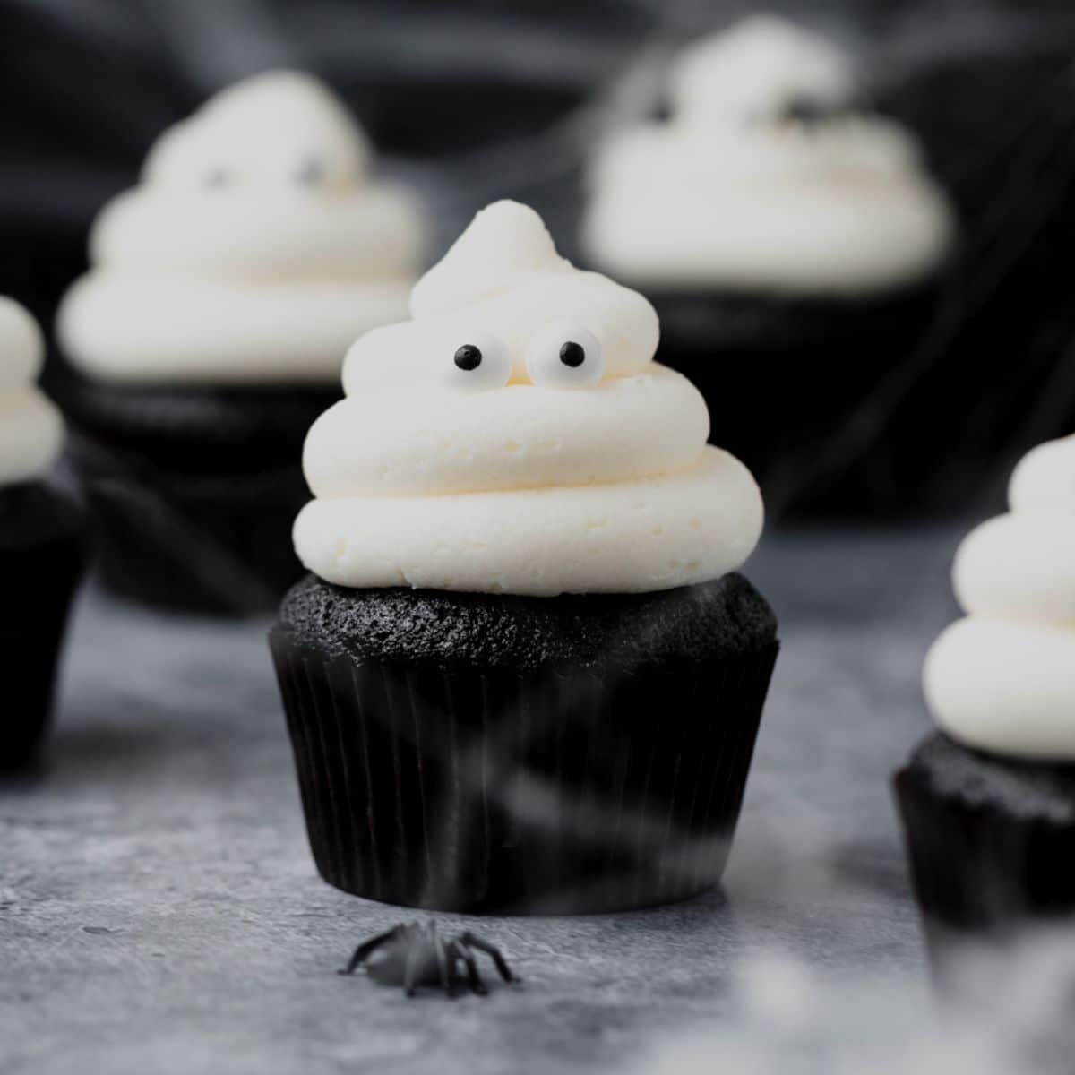 close up shot of black velvet ghost cupcakes.