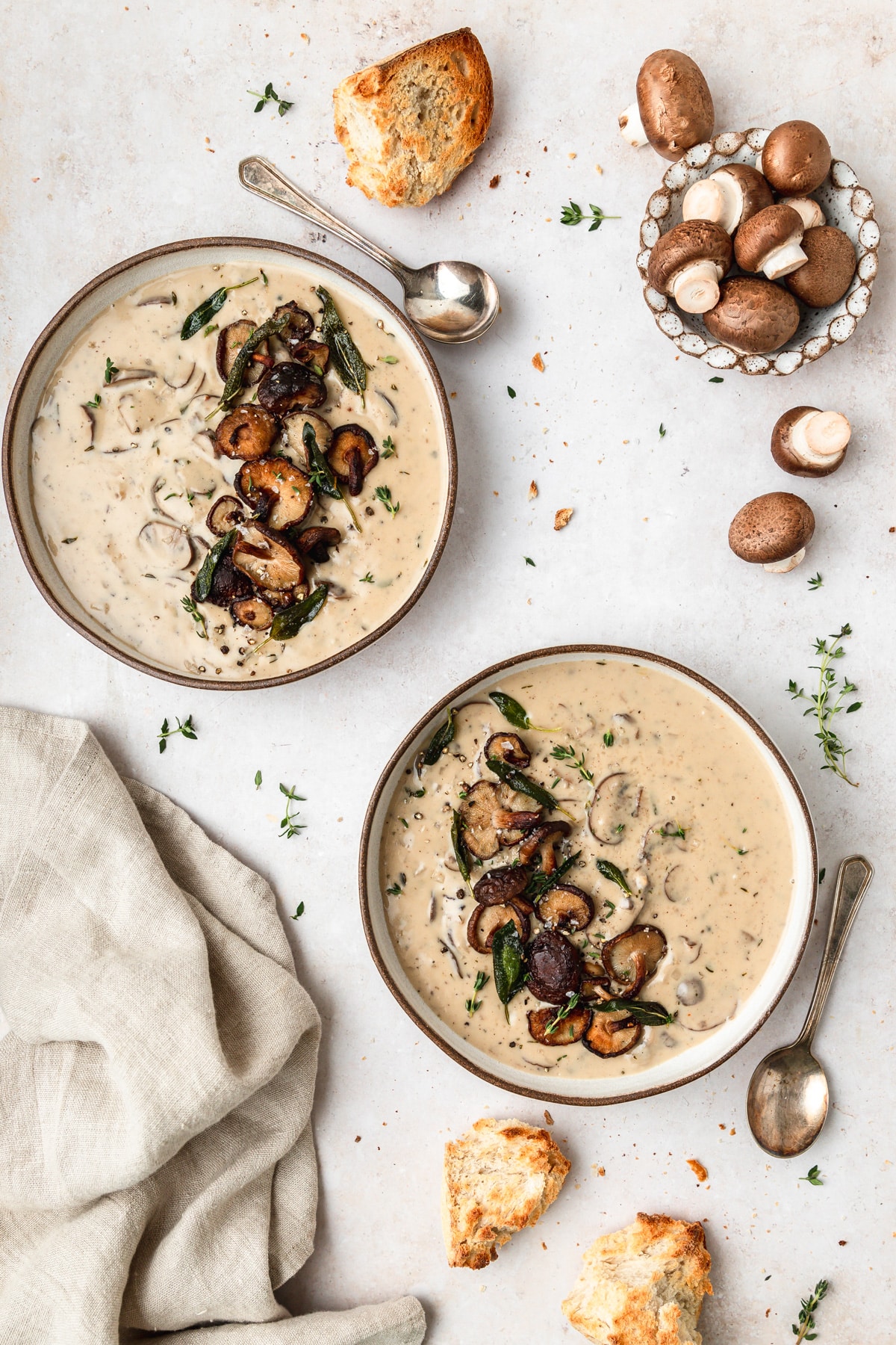 two bowls of homemade cream of mushroom soup with crispy shiitakes.