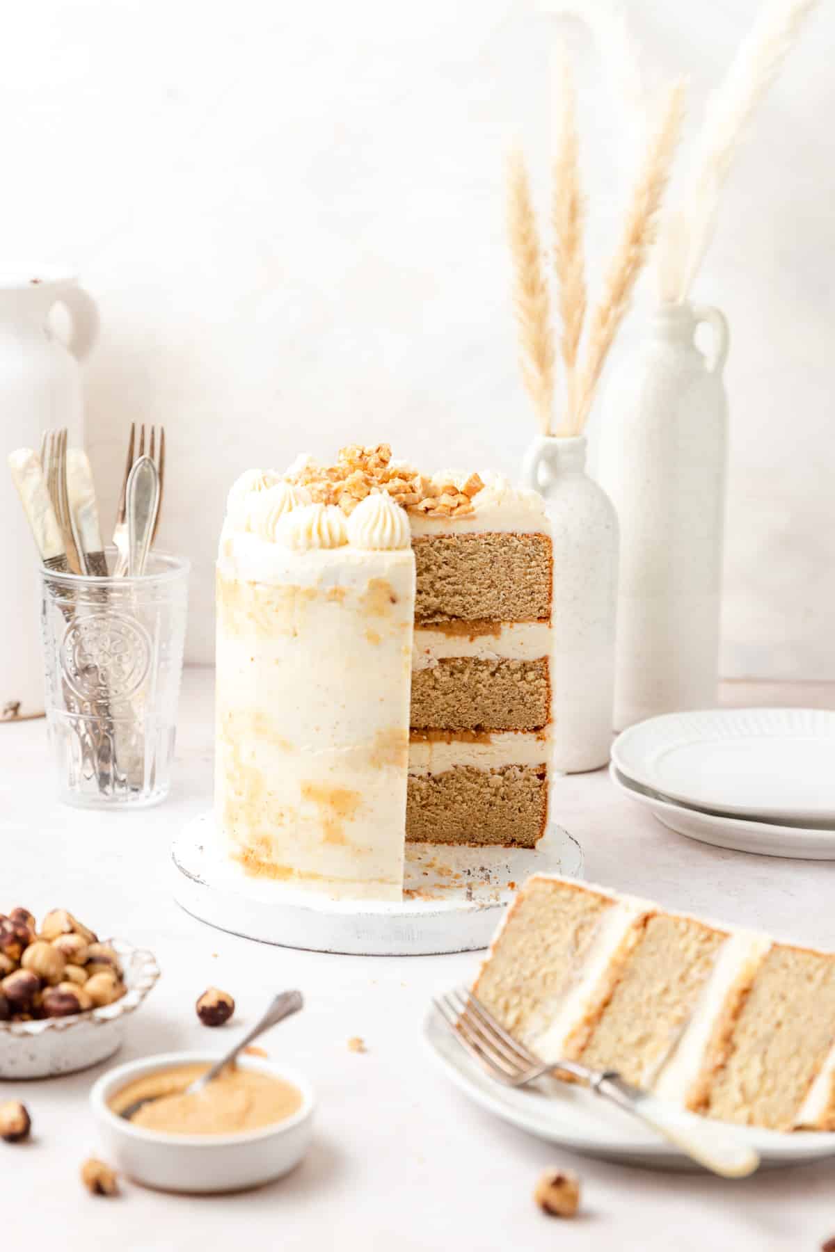 brown butter hazelnut praline layer cake with slice cut out.