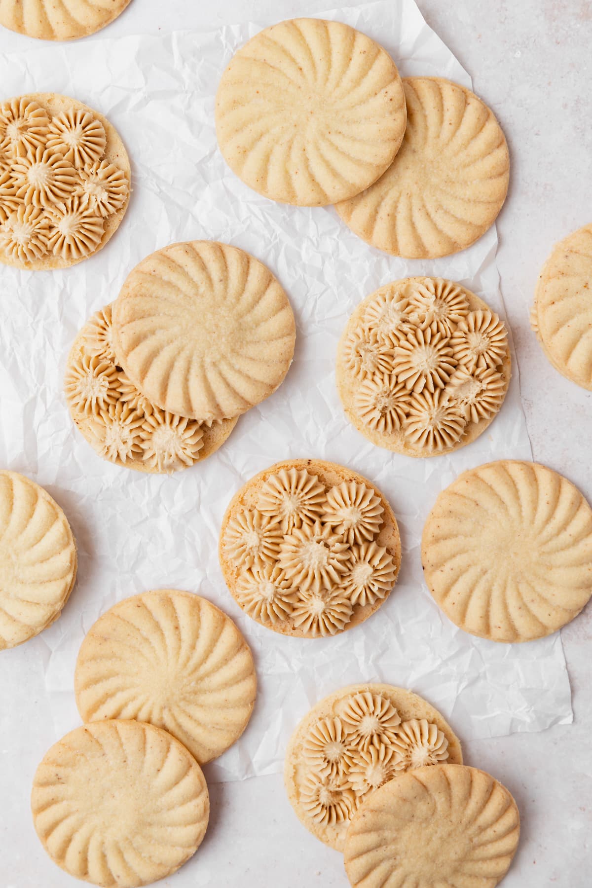 piping maple frosting onto cooled shortbread cookies.