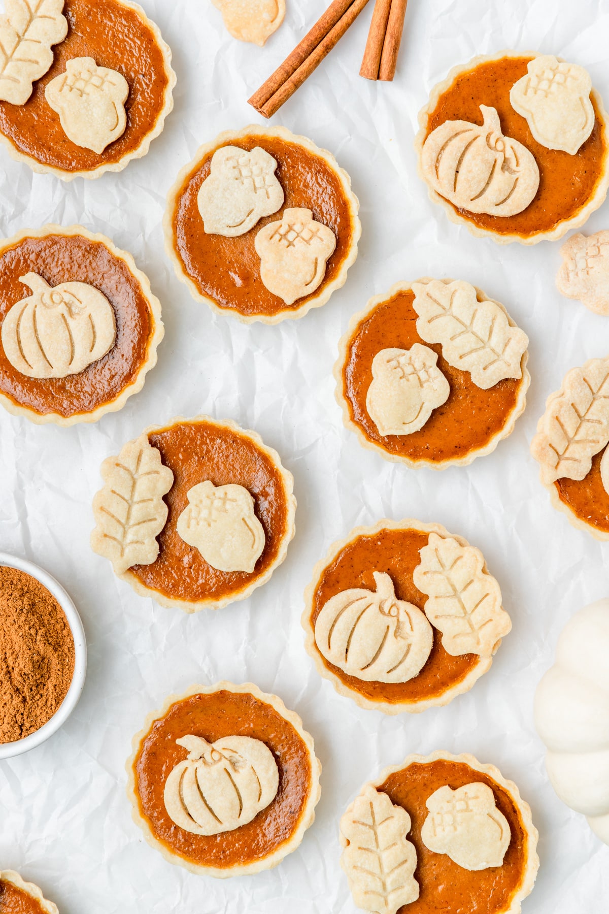 mini pumpkin pie tarts with leaves and acorn cutouts.