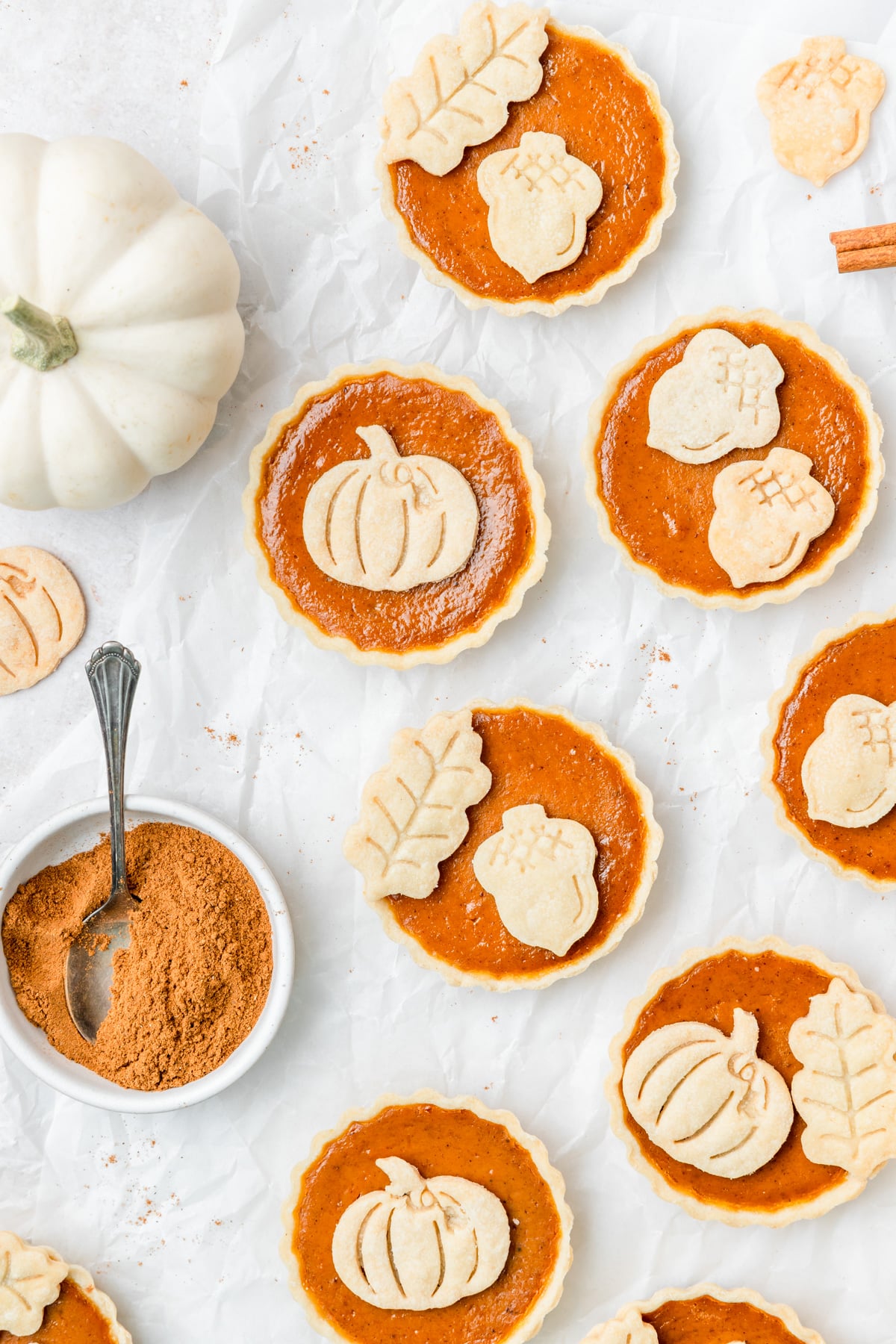 mini pumpkin pie tarts with fall pie crust cutouts.