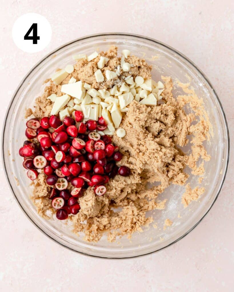 adding fresh cranberries and white chocolate to cookie dough.