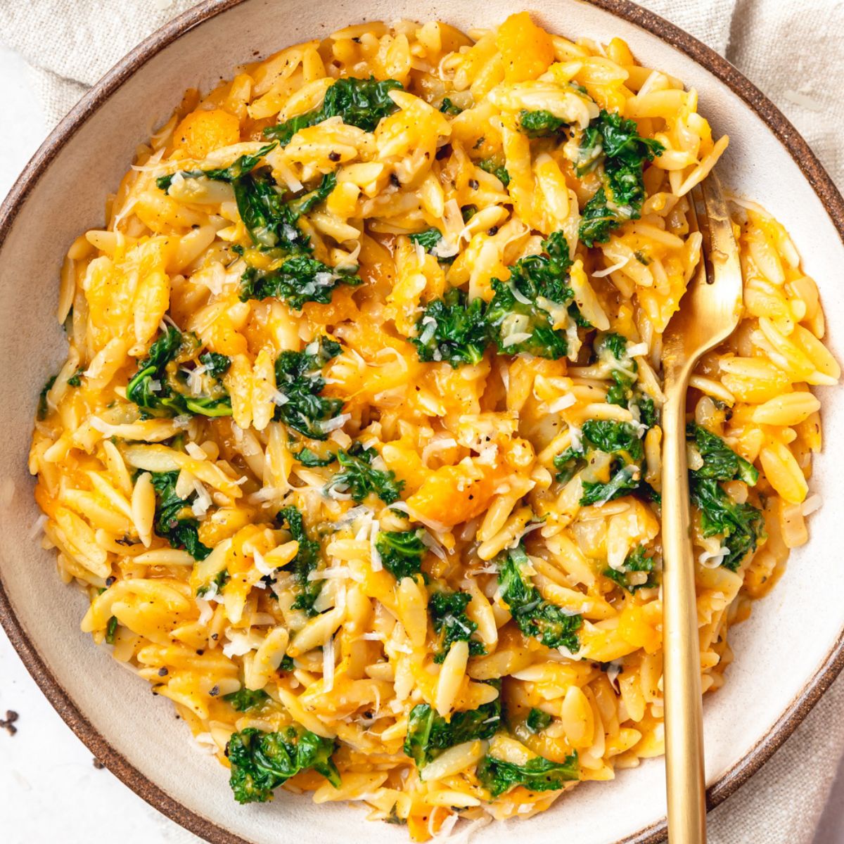 close up shot of butternut squash orzo with kale.