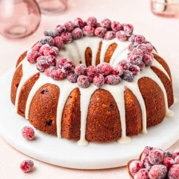 close up shot of cranberry bundt cake with sugared cranberries.