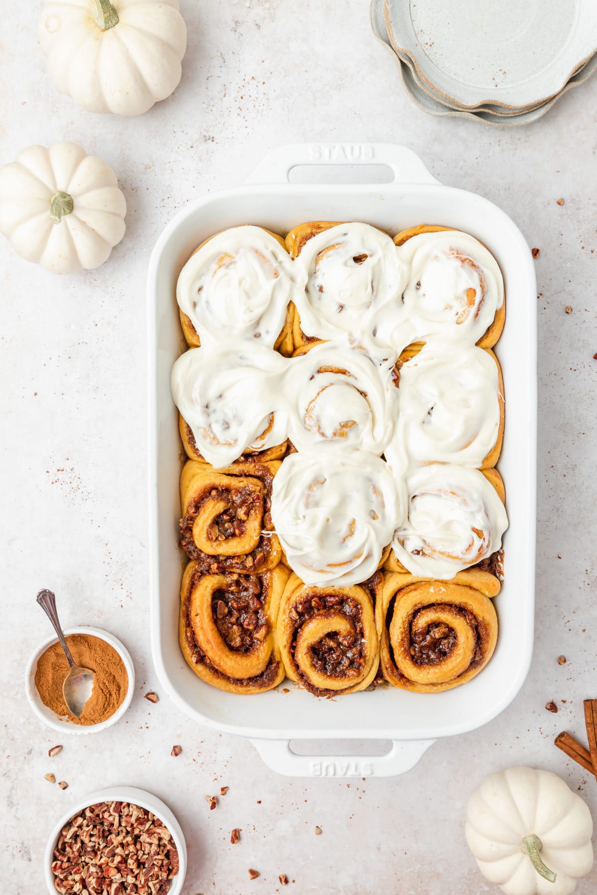 pumpkin spice cinnamon rolls with maple cream cheese frosting.