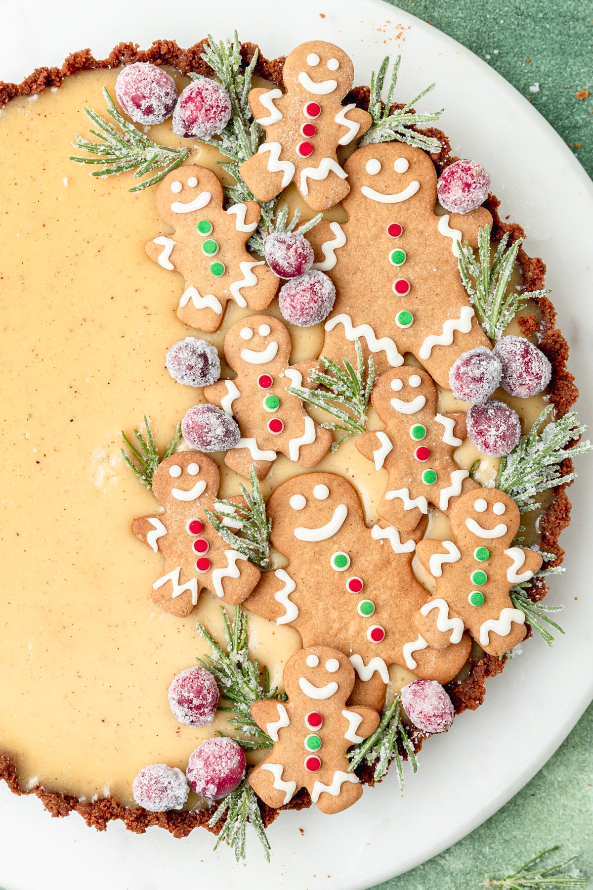 eggnog tart topped with gingerbread cookies and sugared rosemary.