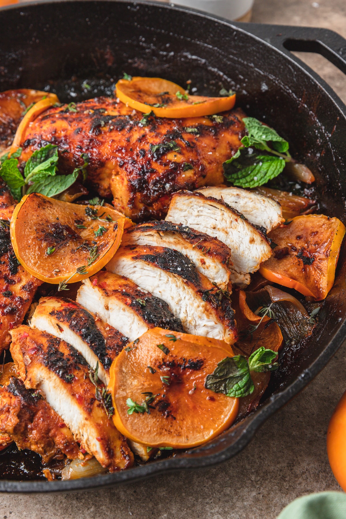 sliced harissa chicken breast with persimmons and mint.
