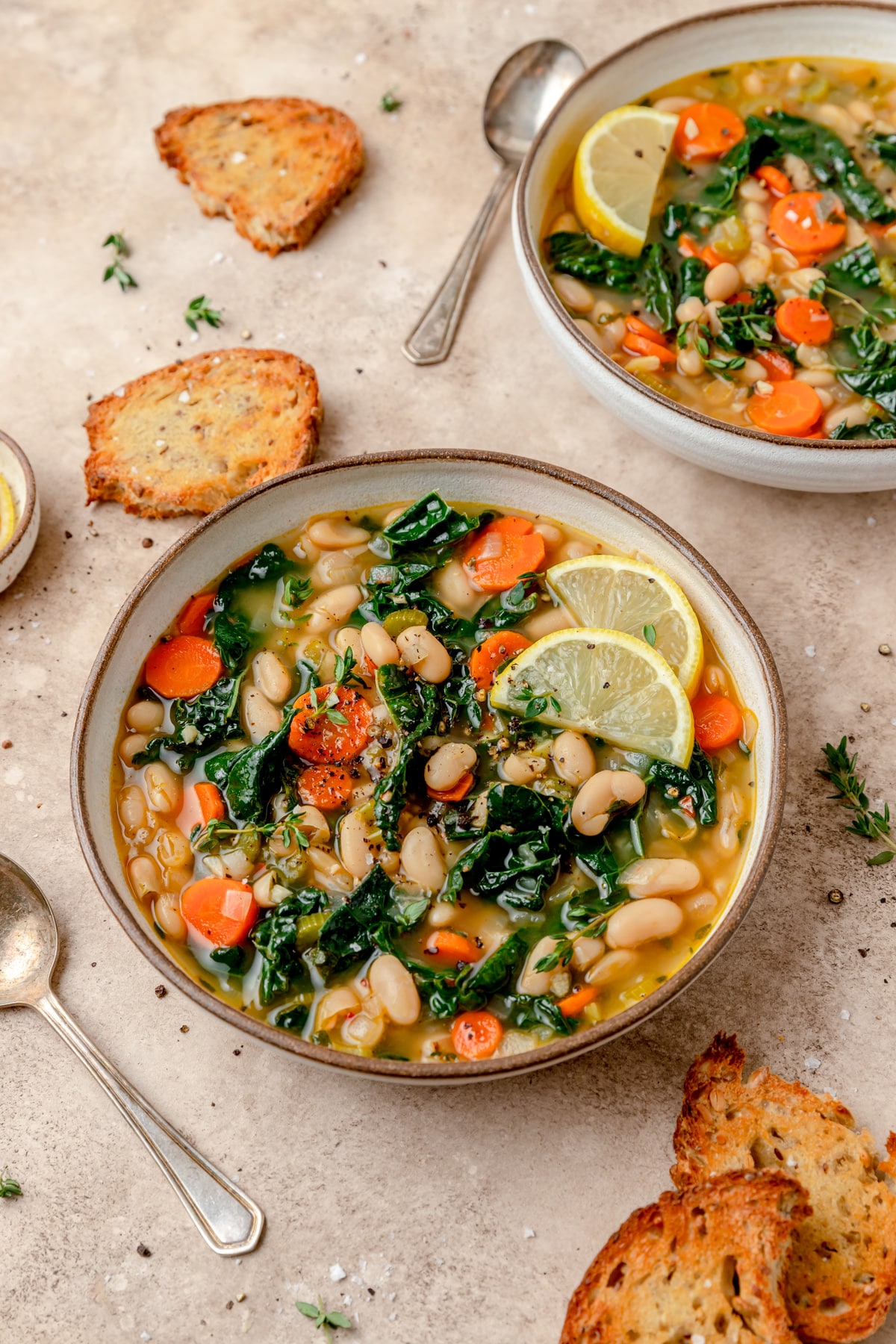 two bowls of white bean soup with kale.
