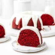 close up shot of red velvet bundt cake with cream cheese glaze.
