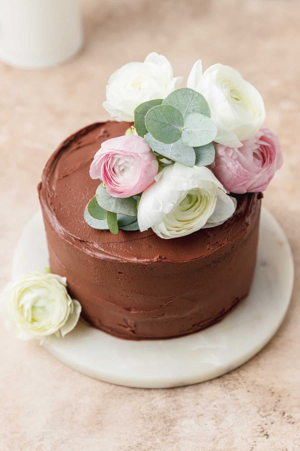 close up shot of red wine chocolate cake topped with flowers.