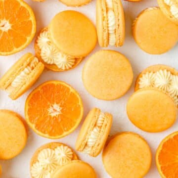 close up shot of orange creamsicle macarons.