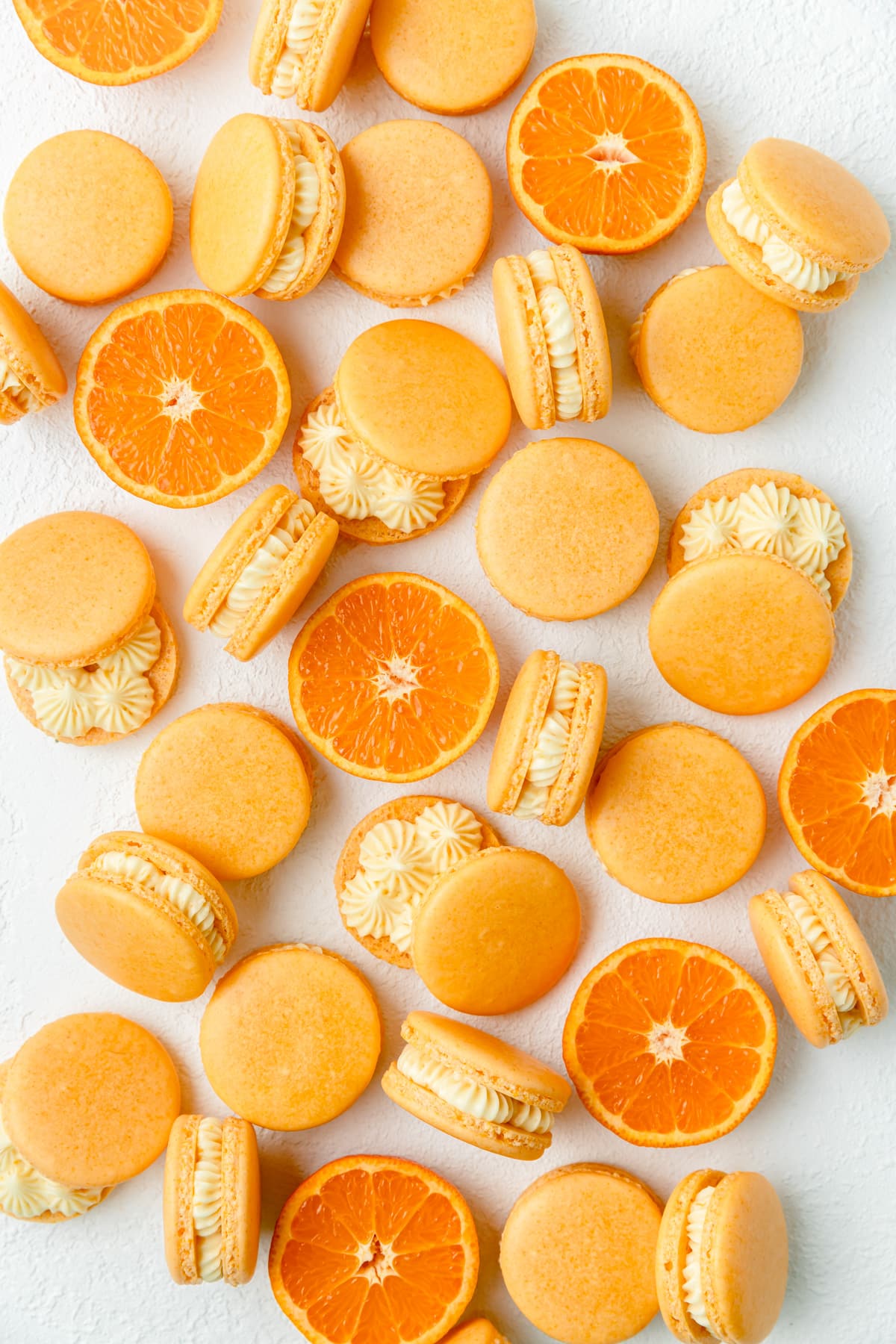 orange creamsicle macarons with sliced oranges.