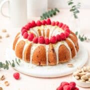 close up of pistachio olive oil bundt cake with raspberries.