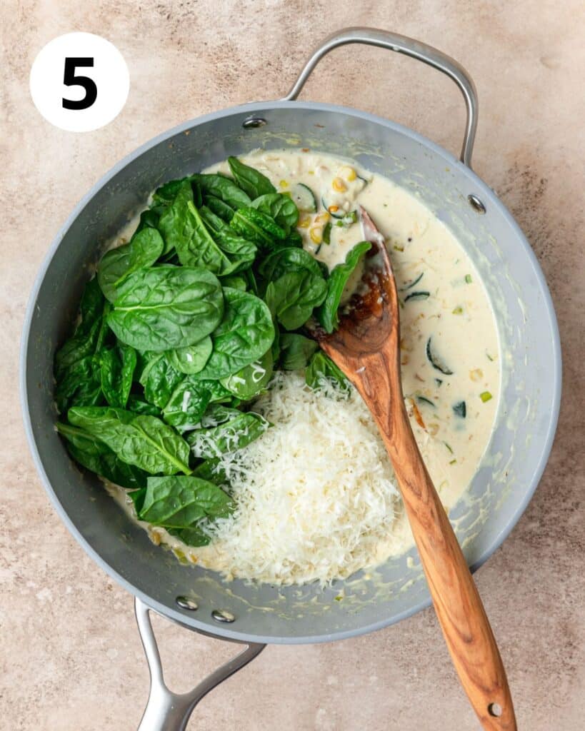 adding spinach and cheese to pasta sauce.