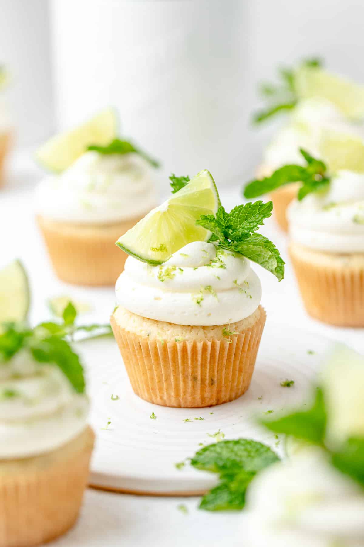 topping mojito cupcakes with mint and lime.