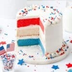 close up of red white and blue layer cake with star sprinkles.