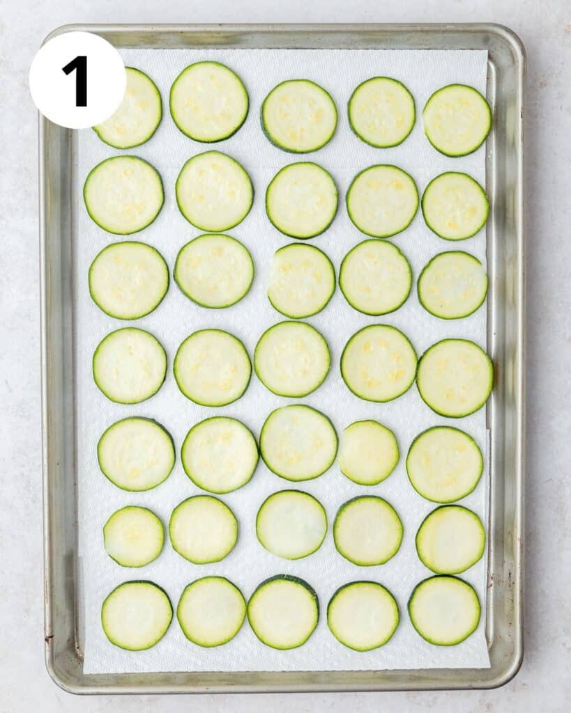 salted zucchini slices on paper towels.