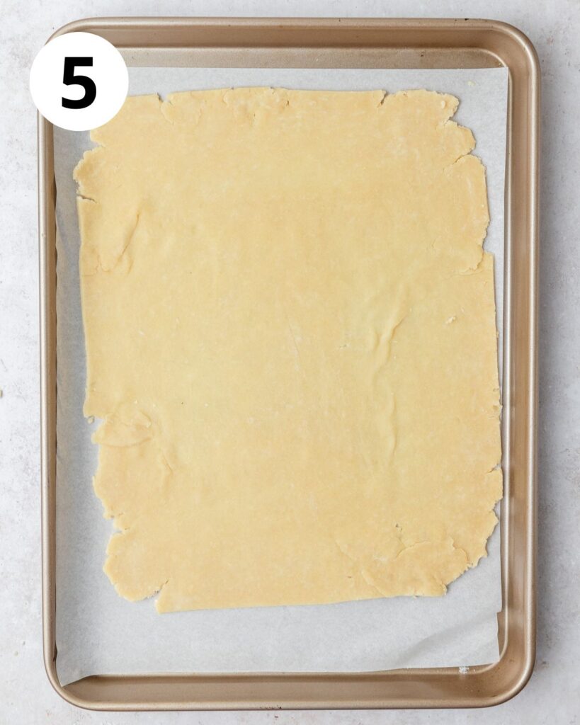 rolling out parmesan pie dough into large rectangle. 