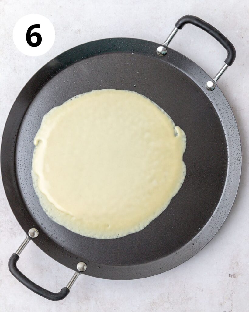 cooking crepes on crepe pan.