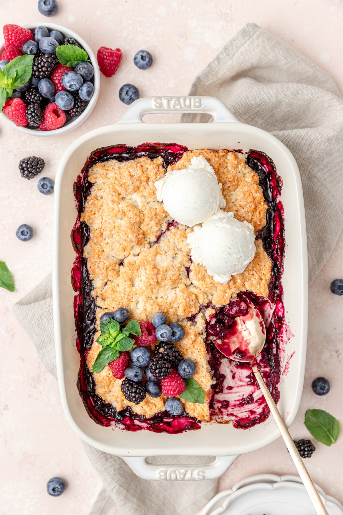 mixed berry cobbler with fresh fruit and vanilla ice cream.
