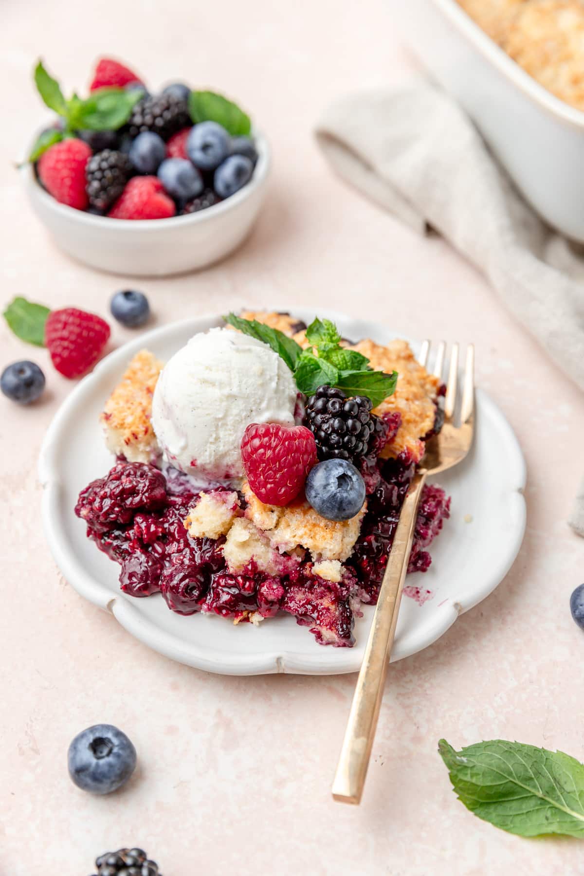 plate of mixed berry cobbler with ice cream.
