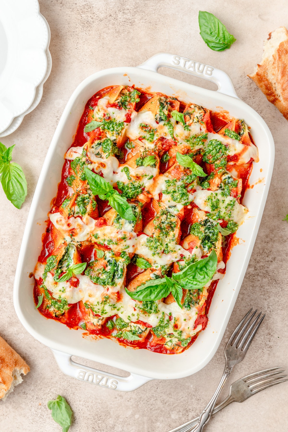 spinach ricotta stuffed shells with red sauce and pesto.