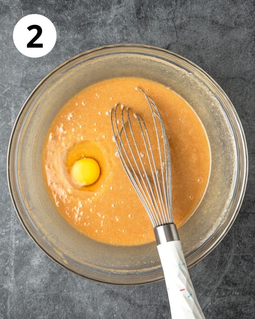 adding eggs to batter one at a time.