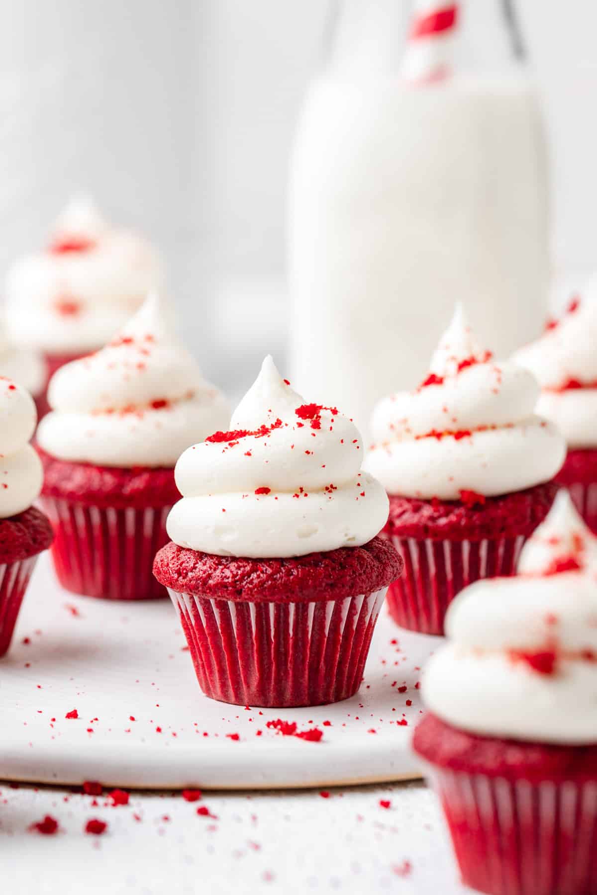 mini red velvet cupcakes with cream cheese frosting and sprinkled with cake crumbs.