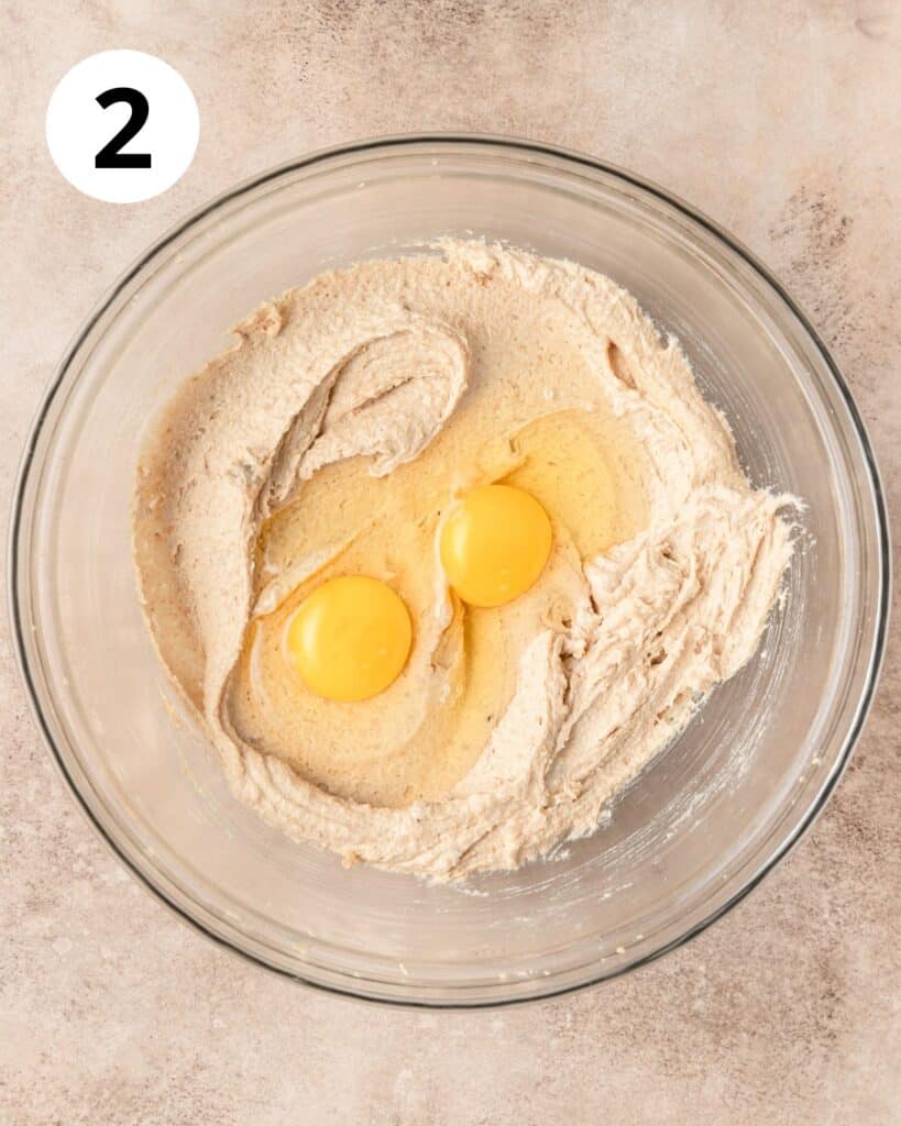 adding eggs to cookie dough.