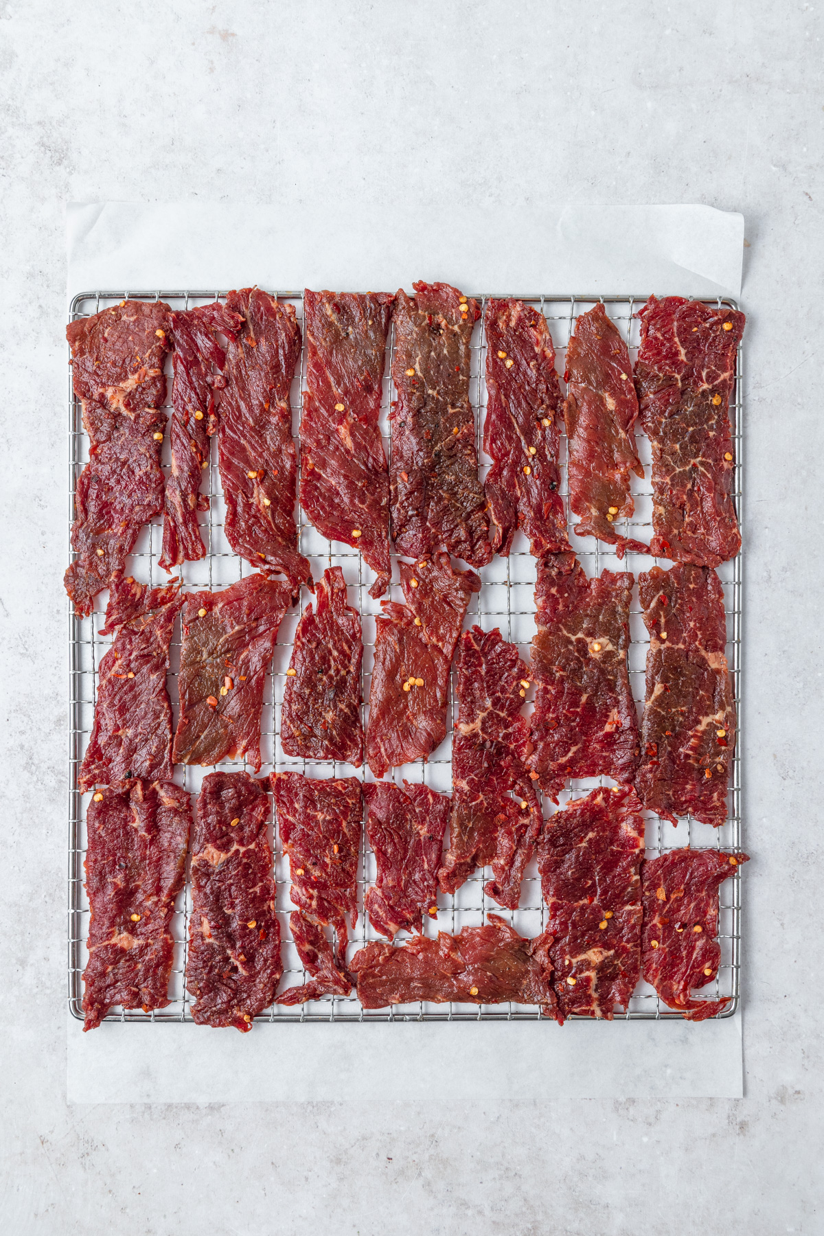beef strips on dehydrator rack before drying.