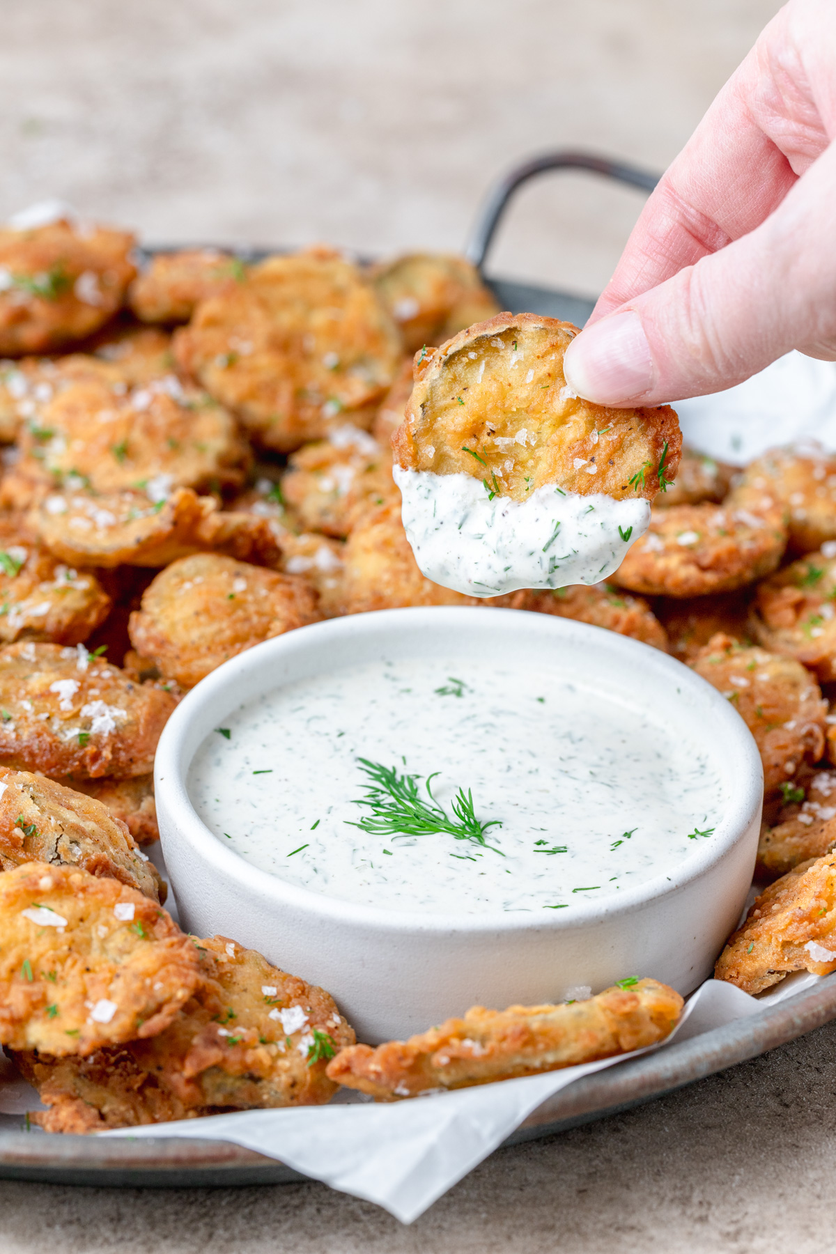 dipping fried pickles in homemade ranch dressing.